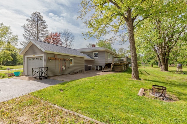 601 N Occidental Rd, Tecumseh, MI 49286 - rear view of property with stairs, a wooden deck, a chimney, driveway, and a lawn