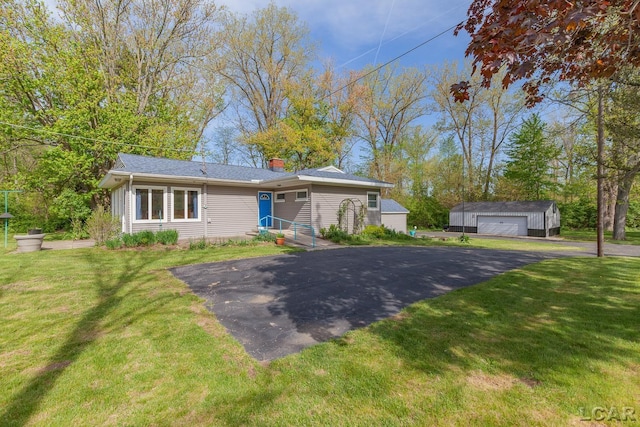 601 N Occidental Rd, Tecumseh, MI 49286 - view of front of home with a garage, an outbuilding, and a front yard
