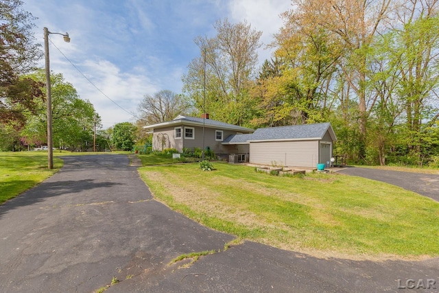 601 N Occidental Rd, Tecumseh, MI 49286 - view of front of house featuring driveway, a front yard, and a chimney