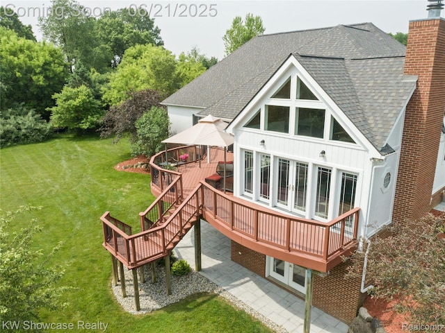 2449 Woodvale Trl, Brighton, MI 48114 - rear view of house featuring a gazebo, a shingled roof, board and batten siding, a wooden deck, and a chimney