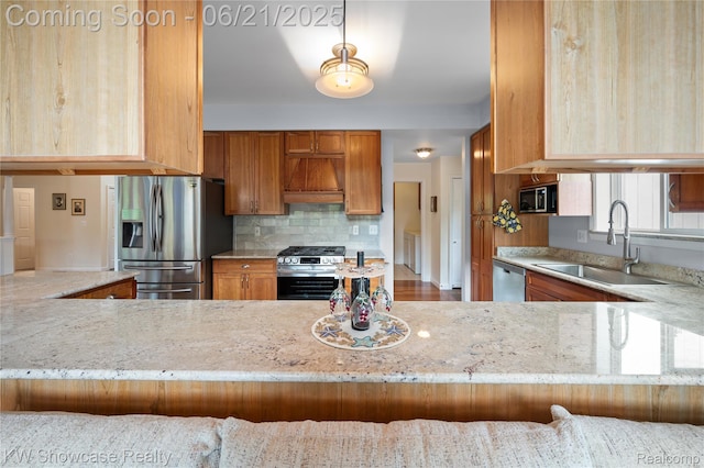 2449 Woodvale Trl, Brighton, MI 48114 - kitchen with stainless steel appliances, custom range hood, light stone counters, brown cabinetry, and tasteful backsplash