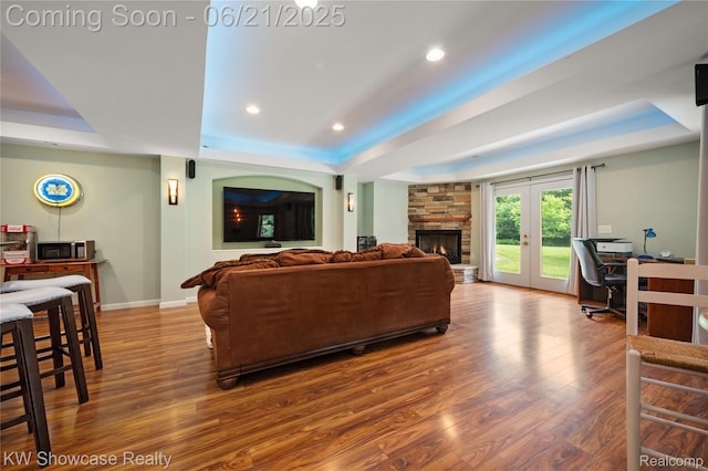 2449 Woodvale Trl, Brighton, MI 48114 - living area with a tray ceiling, wood finished floors, a fireplace, an office area, and recessed lighting