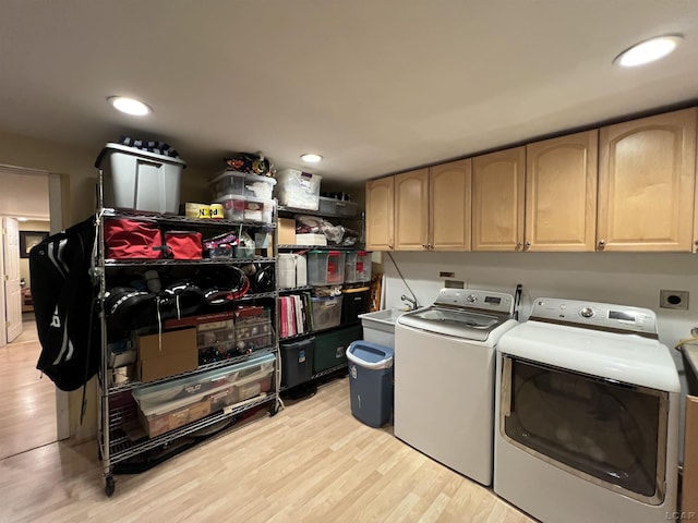 9299 Parkland Dr, Ypsilanti, MI 48197 - clothes washing area featuring washing machine and dryer, cabinet space, light wood-style flooring, and recessed lighting