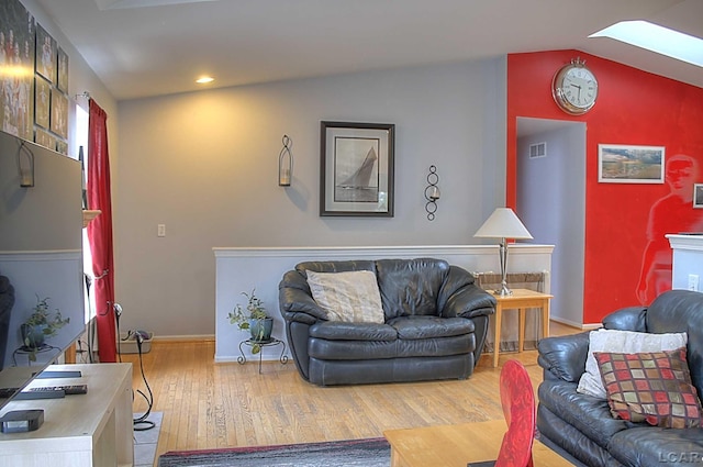 9299 Parkland Dr, Ypsilanti, MI 48197 - living room featuring wood finished floors, baseboards, lofted ceiling, a skylight, and recessed lighting