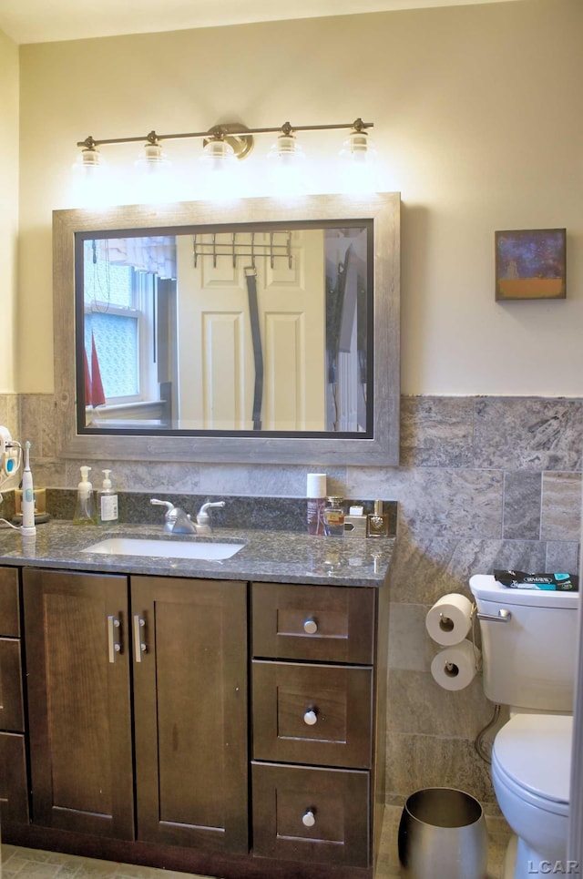 9299 Parkland Dr, Ypsilanti, MI 48197 - bathroom featuring tile walls, vanity, toilet, and wainscoting