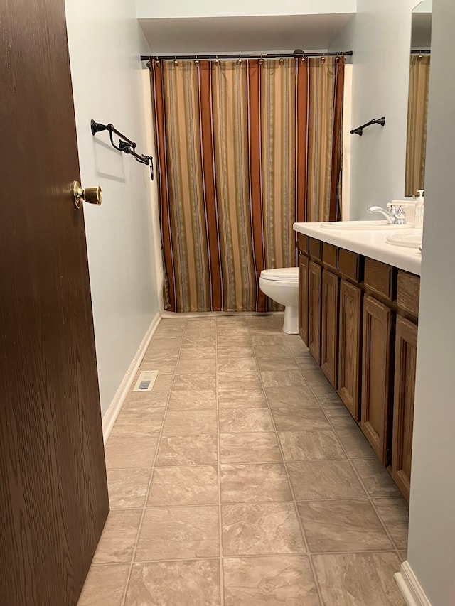 11300 Hegel Rd, Goodrich, MI 48438 - bathroom with toilet, vanity, and baseboards