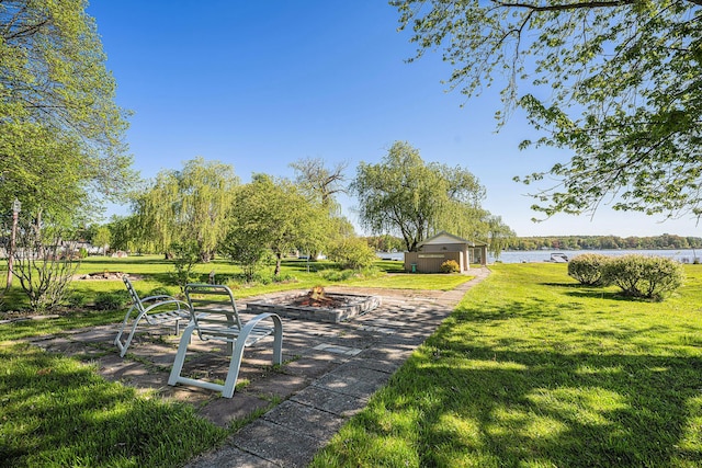 3309 Dumont Lake Dr, Allegan, MI 49010 - view of property's community featuring a fire pit, a lawn, and a water view