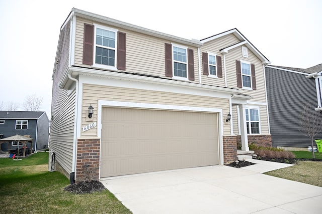 view of front of house featuring an attached garage, brick siding, concrete driveway, and a front yard