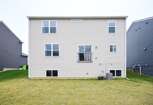 rear view of property with a yard and central AC