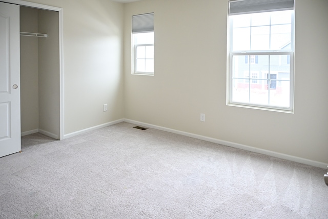 unfurnished bedroom with carpet flooring, baseboards, and a closet