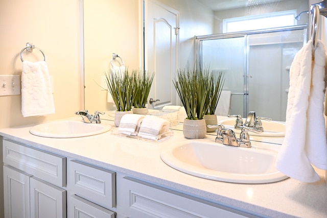 full bathroom with double vanity and an enclosed shower