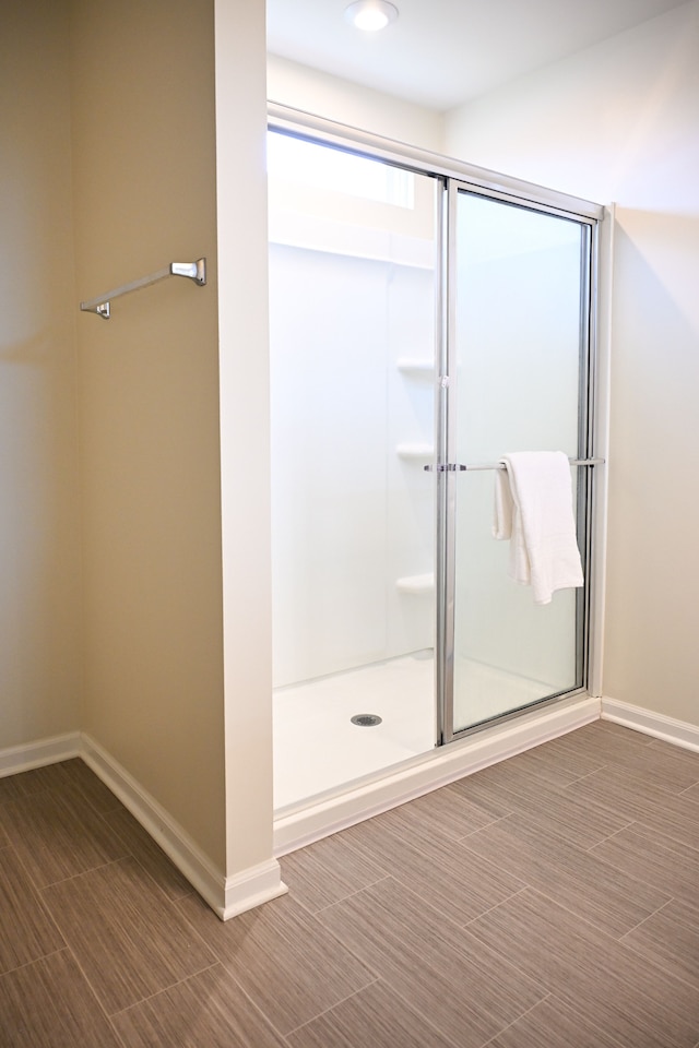 full bath featuring a stall shower and baseboards