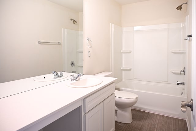 bathroom featuring toilet, vanity, and bathtub / shower combination