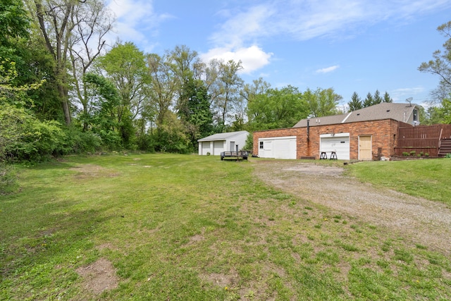view of yard featuring dirt driveway and a detached garage