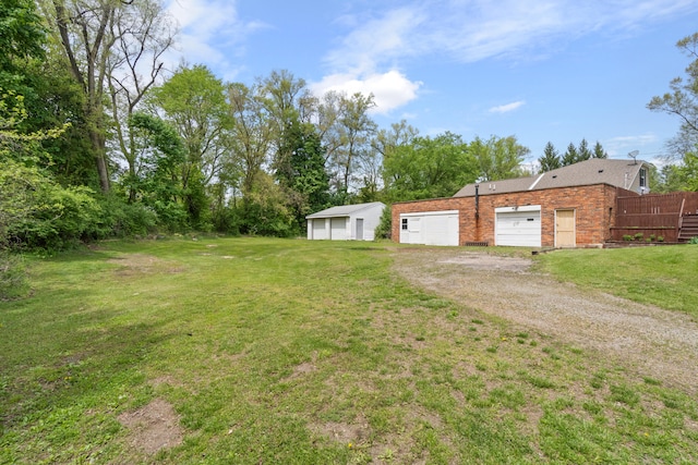 view of yard featuring driveway and a detached garage