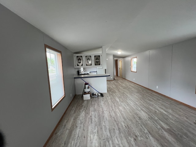 4085 Mapleview Ct E, Brown City, MI 48416 - unfurnished living room with wood finished floors, lofted ceiling, plenty of natural light, and baseboards