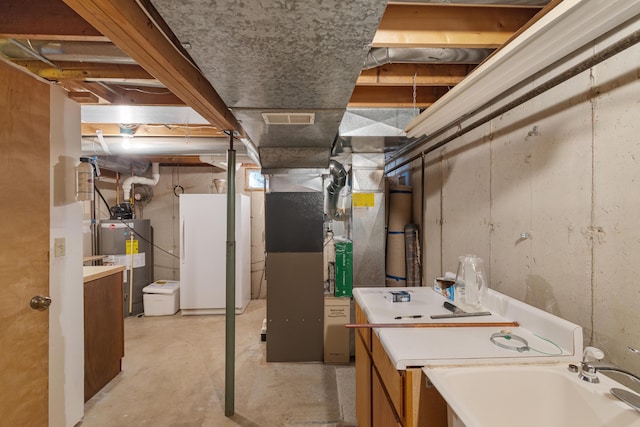 14427 Acorn Cove Trl, Battle Creek, MI 49017 - unfinished below grade area with water heater, heating unit, and freestanding refrigerator
