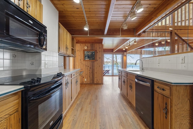 14427 Acorn Cove Trl, Battle Creek, MI 49017 - kitchen with track lighting, black appliances, a sink, light wood-style floors, and tasteful backsplash