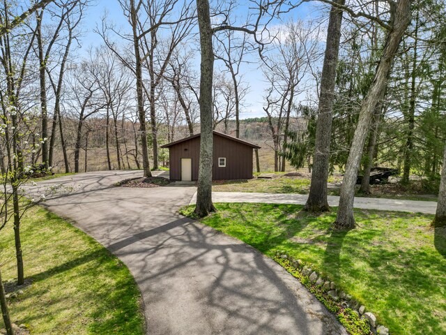 14427 Acorn Cove Trl, Battle Creek, MI 49017 - view of front of home with an outbuilding, curved driveway, and a garage