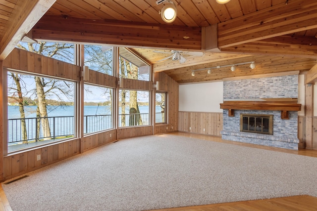 14427 Acorn Cove Trl, Battle Creek, MI 49017 - unfurnished living room with wood walls, a water view, wooden ceiling, a glass covered fireplace, and wood finished floors