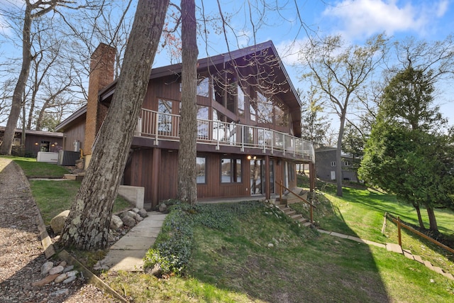 14427 Acorn Cove Trl, Battle Creek, MI 49017 - back of property featuring a lawn, central air condition unit, a deck, and a chimney