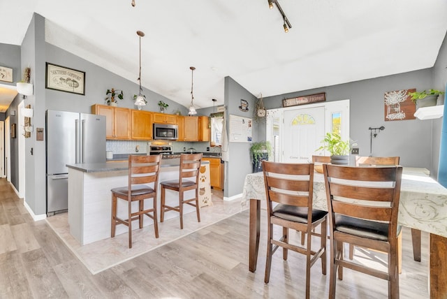 144 Westshore Dr, Jerome, MI 49249 - dining area with light wood-type flooring, lofted ceiling, and baseboards