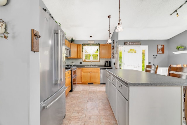 144 Westshore Dr, Jerome, MI 49249 - kitchen featuring stainless steel appliances, a sink, decorative backsplash, a center island, and dark countertops