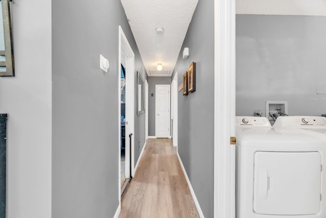 144 Westshore Dr, Jerome, MI 49249 - hall featuring a textured ceiling, light wood-style flooring, washing machine and dryer, and baseboards