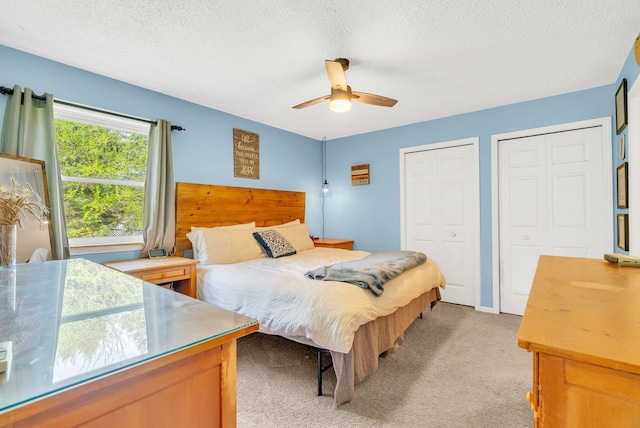 144 Westshore Dr, Jerome, MI 49249 - bedroom featuring two closets, light carpet, a textured ceiling, and a ceiling fan