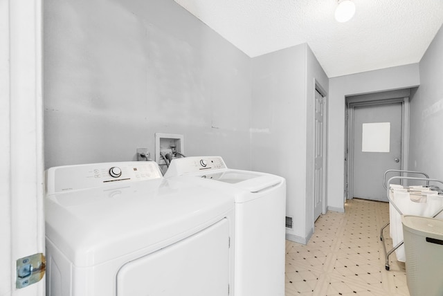 144 Westshore Dr, Jerome, MI 49249 - clothes washing area with light flooring, washing machine and dryer, and a textured ceiling