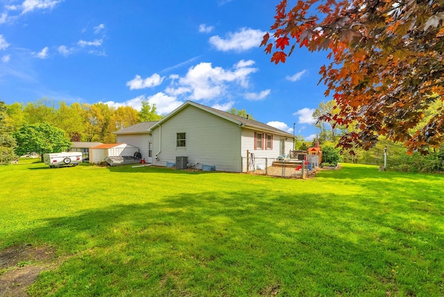144 Westshore Dr, Jerome, MI 49249 - rear view of property featuring central air condition unit and a lawn