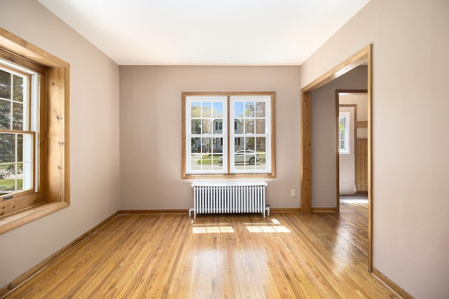 805 E Filer St, Ludington, MI 49431 - unfurnished room with radiator, light wood finished floors, and baseboards