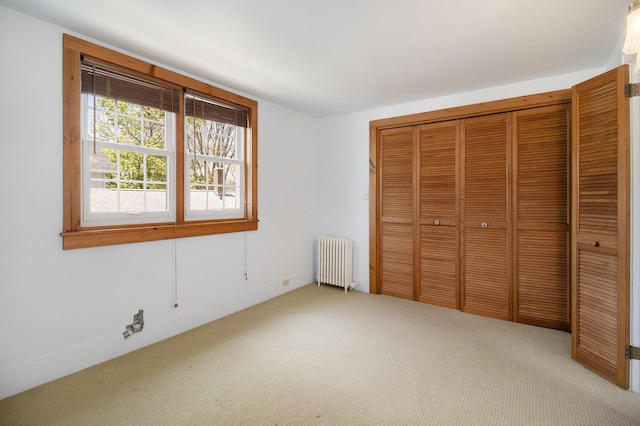 805 E Filer St, Ludington, MI 49431 - unfurnished bedroom featuring radiator, carpet, and a closet