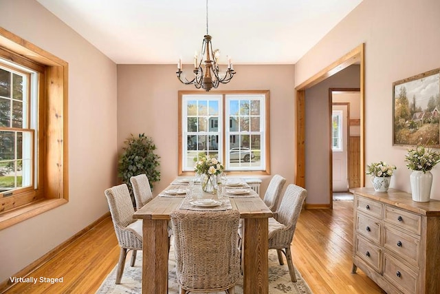 805 E Filer St, Ludington, MI 49431 - dining space with a chandelier, light wood-style floors, and baseboards