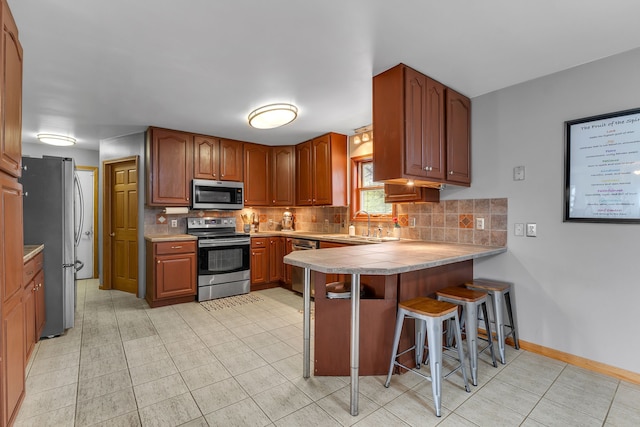 17035 Weber Rd, Holly, MI 48442 - kitchen featuring stainless steel appliances, a peninsula, tasteful backsplash, and a breakfast bar area