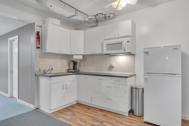 17035 Weber Rd, Holly, MI 48442 - kitchen featuring white appliances, a sink, dark countertops, white cabinetry, and a drop ceiling