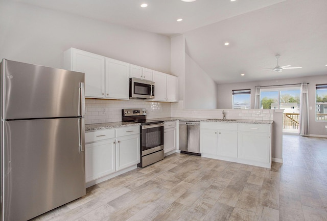 10315 Hatch Ln, Galesburg, MI 49053 - kitchen with stainless steel appliances, a sink, a peninsula, white cabinets, and recessed lighting