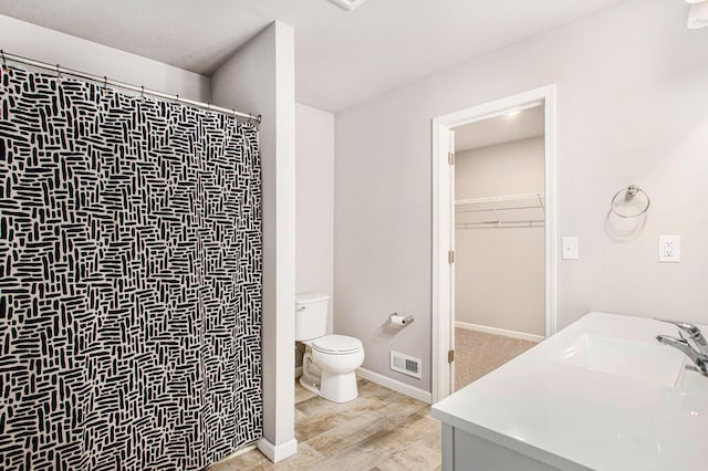 10315 Hatch Ln, Galesburg, MI 49053 - full bathroom featuring toilet, wood finished floors, a shower with curtain, a walk in closet, and baseboards