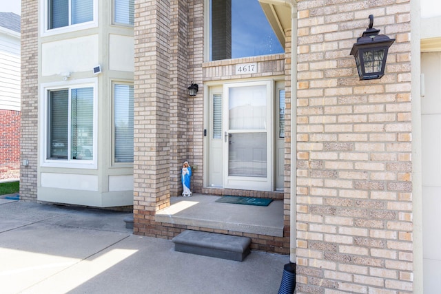 doorway to property with brick siding
