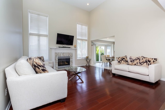 living room featuring a tile fireplace, wood finished floors, baseboards, and recessed lighting