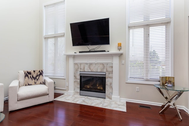 living room featuring wood finished floors, a premium fireplace, and baseboards