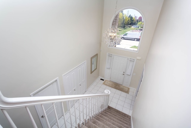 entryway featuring stairway, a high ceiling, and tile patterned floors