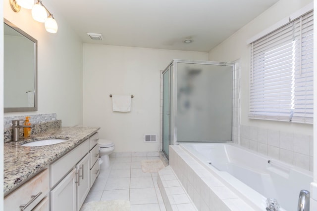 bathroom featuring vanity, a shower stall, a bath, tile patterned flooring, and toilet