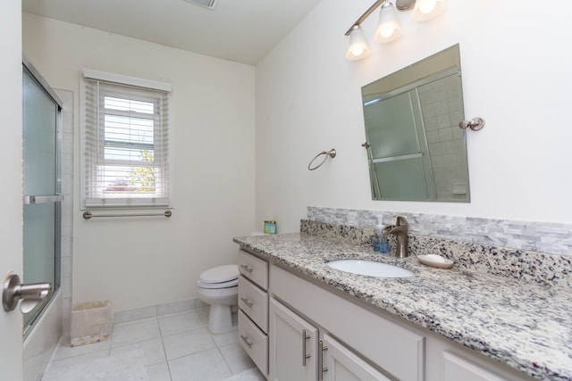 full bath with tile patterned floors, vanity, toilet, combined bath / shower with glass door, and baseboards