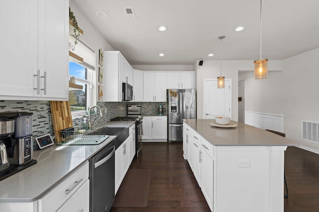 4051 Colfax Ct, Canton, MI 48188 - kitchen featuring appliances with stainless steel finishes, backsplash, dark wood finished floors, a kitchen island, and recessed lighting