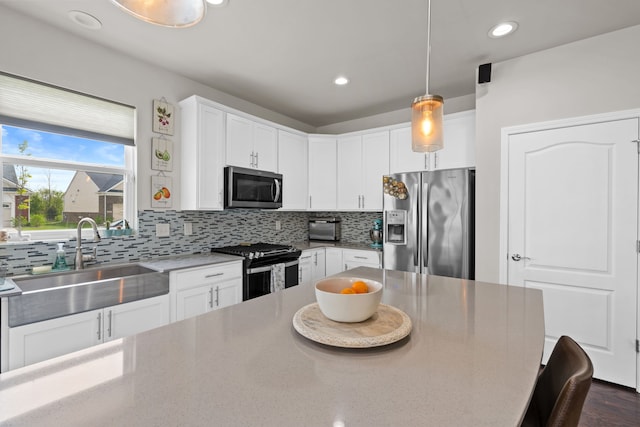 4051 Colfax Ct, Canton, MI 48188 - kitchen featuring stainless steel appliances, a sink, tasteful backsplash, white cabinetry, and decorative light fixtures