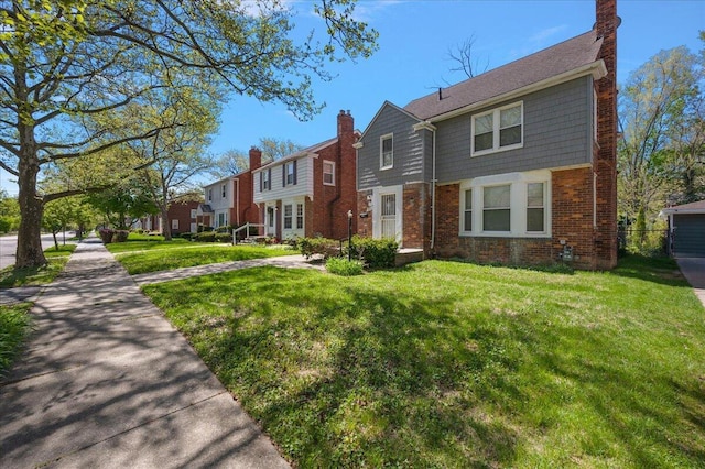 5921 Hillcrest St, Grosse Pointe, MI 48236 - view of property featuring brick siding, a front lawn, and a chimney