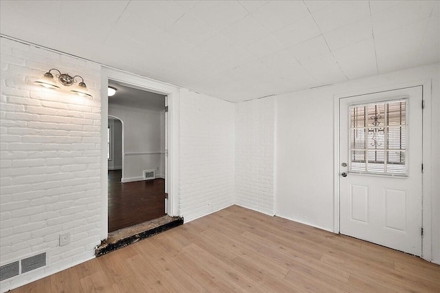 5921 Hillcrest St, Grosse Pointe, MI 48236 - unfurnished room with brick wall, light wood-style flooring, and arched walkways