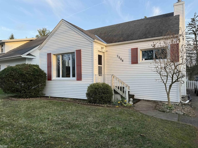 1566 Snyder Rd, East Lansing, MI 48823 - view of front of house featuring a front lawn, a chimney, and a shingled roof