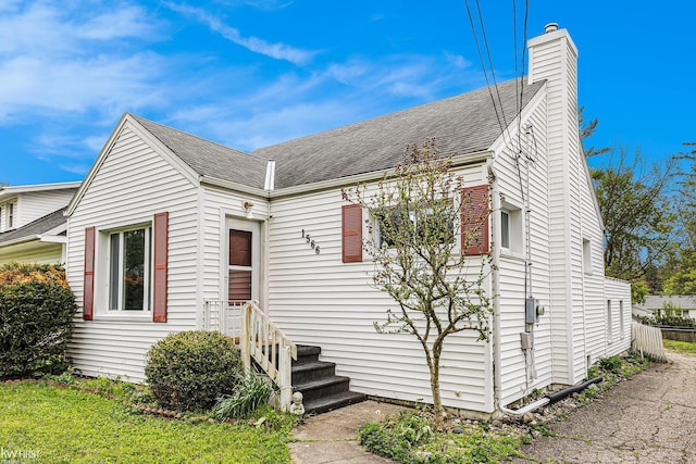 1566 Snyder Rd, East Lansing, MI 48823 - view of front of home with roof with shingles and a chimney